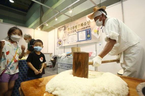 신기한 전통떡매치기 - 2022 ‘제21회 친환경유기농무역박람회 및 귀농귀촌체험학습박람회’를 찾은 어린이들이 전통떡매치기 시연을 보고 있다(위 기사와 관련 없음). 연합뉴스