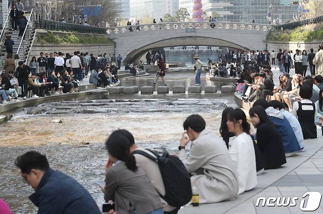 낮 기온이 전국 대부분 지역에서 20도 이상으로 올라 초여름 날씨를 보인 31일 서울 청계천에서 시민들이 휴식을 취하고 있다. 2023.3.31/뉴스1 ⓒ News1 송원영 기자