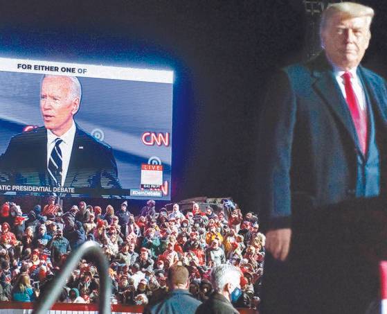 도널드 트럼프 미국 대통령이 2020년 10월 20일 펜실베이니아주 이리 국제공항에서 열린 대중 유세에서 경쟁자인 조 바이든 민주당 대선 후보가 나온 CNN 화면을 바라보고 있다. AFP
