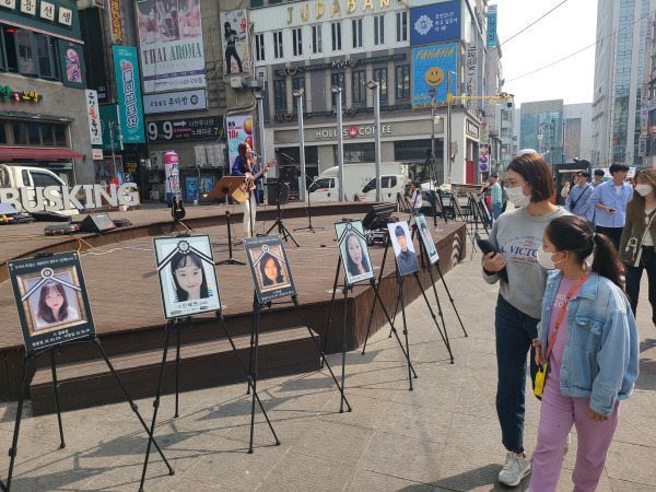 1일 인천 남동구 구월동 로데오 광장에서 시민들이 ㈔코로나19백신피해자가족협의회가 마련한 버스킹 공연을 보며 지나가고 있다. 이승륜 기자