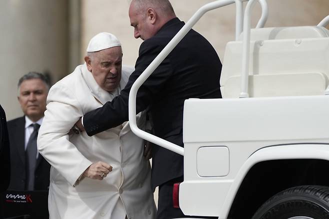 프란치스코 교황(두번째)이 지난달 29일(현지시간) 바티칸 성 베드로 광장에서 열린 수요 일반 알현 후에 부축을 받으며 차량에 오르는 모습. [연합]