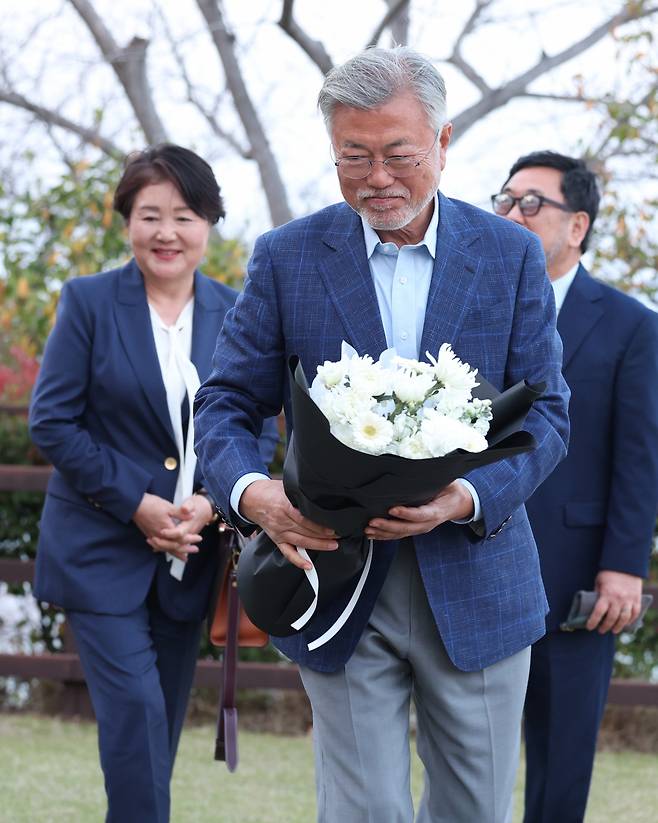 Former South Korean President Moon Jae-in (center) and his wife Kim Jung-sook (left) pay a visit to the late composer Yun I-sang's grave, before attending a performance by the Tongyeong Festival Orchestra on the first day of the 21st Tongyeong International Music Festival on Friday. (Yonhap)
