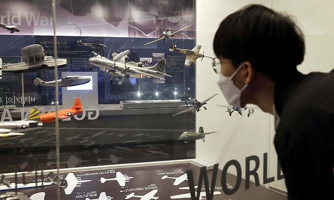 1, 2차 세계대전 때 활약했던 전투기 모형들을 관람객이 보고 있다. 전투기들은 1, 2차 대전을 거치면서 비약적으로 발전하였다.