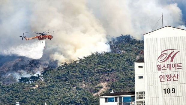 < 화마에 휩싸인 인왕산 > 2일 오전 서울 부암동 인왕산에서 원인을 알 수 없는 화재가 발생했다. 소방당국은 이날 오후 3시 현재 산림 14만㎡가 불에 탔다고 밝혔다. 소방헬기가 불길이 번지는 인왕산 위에서 진화 작업을 하고 있다.  뉴스1
