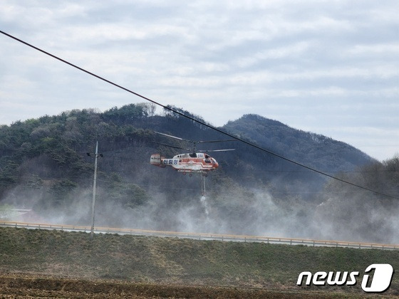 4일 오후 1시 홍성 산불의 발화지인 서부면 중리 538번지 야산 아래 저수지에서 헬기가 산불진화에 사용할 물을 담수하고 있다. 헬기 뒷편이 홍성 산불 발원지다.(대전ㆍ충남=뉴스1) 이찬선 기자