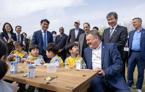 The BIE delegation greets with kids on Tuesday at Eulsukdo. [YONHAP]