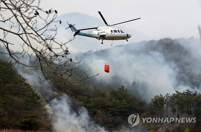 4일 오전 전남 함평군 대동면 연암리 대동저수지 인근 야산에서 전남도 소속 헬기가 진화 작업하고 있다.[연합]