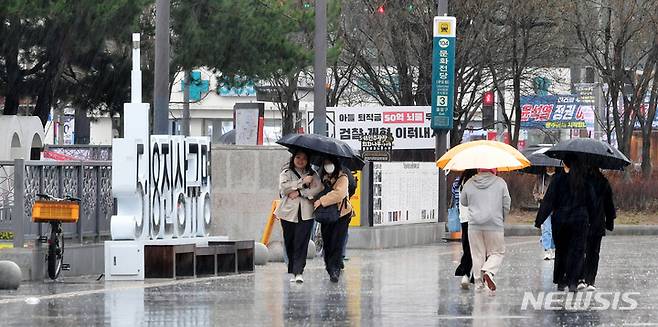 [광주=뉴시스] 이영주 기자 = 비가 내리는 지난달 12일 오전 광주 동구 5·18민주광장에서 시민들이 우산을 쓴 채 걷고 있다. 2023.03.12. leeyj2578@newsis.com