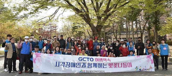 경북문화관광공사 김성조 사장이 벚꽃나들이 행사에 참가한 시각장애인 어르신들과 기념촬영을 하고 있다. 공사 제공