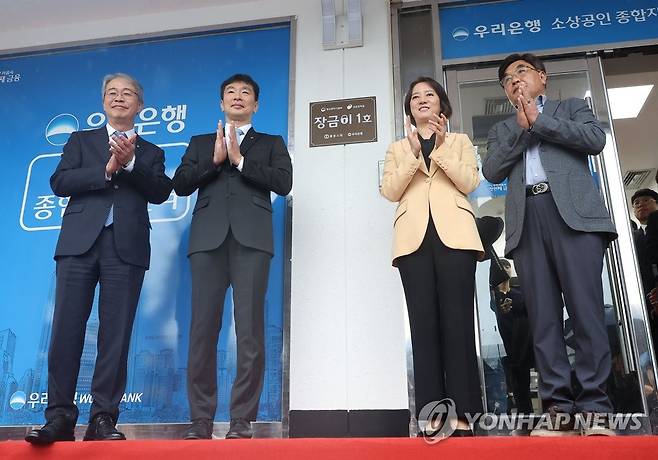 전통시장 상인 금융 환경 개선 창구, '장금이 1호' 현판식 (서울=연합뉴스) 류영석 기자 = 이복현 금융감독원장과 이영 중소벤처기업부 장관이 5일 오전 서울 광장시장 앞 우리은행 종로4가금융센터에서 열린 전통시장 상인 금융사기 피해 예방과 맞춤형 금융상담창구 현판식에 참석해 현판에 싸인 천을 제거한 뒤 박수를 치고 있다. 2023.4.5 ondol@yna.co.kr