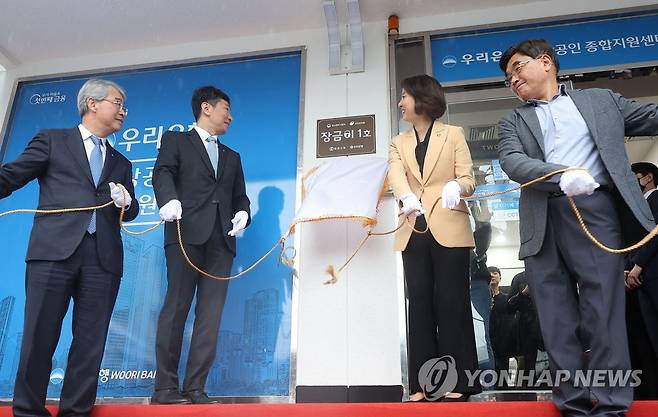 전통시장 상인 금융 환경 개선 창구, '장금이 1호' 현판식 (서울=연합뉴스) 류영석 기자 = 이복현 금융감독원장과 이영 중소벤처기업부 장관이 5일 오전 서울 광장시장 앞 우리은행 종로4가금융센터에서 열린 전통시장 상인 금융사기 피해 예방과 맞춤형 금융상담창구 현판식에 참석해 현판에 싸인 천을 제거하고 있다. 2023.4.5 ondol@yna.co.kr