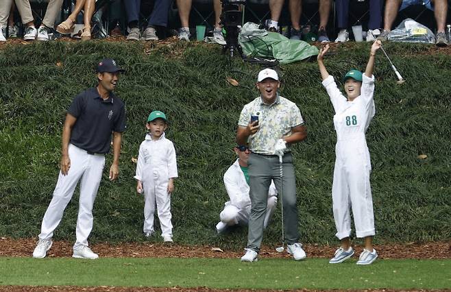 오지현(맨 오른쪽)이 6일(한국시간) 미국 조지아주 오거스타의 오거스타 내셔널 골프클럽에서 열린 마스터스 개막 이벤트 파3 콘테스트에서 남편 김시우의 캐디로 나섰다가 9번홀에서 대신 티샷한 공이 홀 70cm에 붙자 펄쩍 뛰며 기뻐하고 있다. 옆에서 오지현의 티샷을 지켜보고 있던 김시우(가운데)와 케빈 나다 함께 기뻐하고 있다. (사진=AFPBBNews)