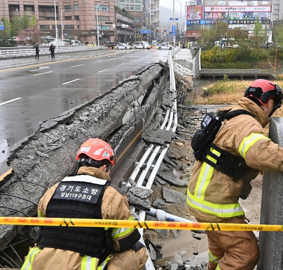 5일 오전 경기도 성남시 분당구 정자교의 한쪽 보행로가 무너지는 사고가 발생해 출동한 소방대원들이 현장을 수습하고 있다. 이 다리는 1993년 6월 사용 승인을 받은 30년 된 다리다. [뉴시스]