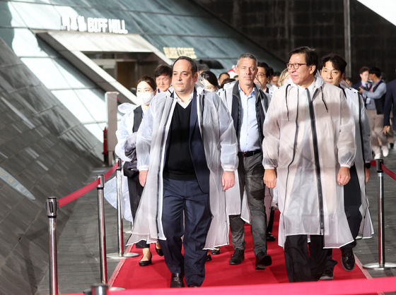 The BIE delegation and Busan Mayor Park Heong-joon, right, walk on the red carpet to attend K-Culture Night on Wednesday night. [YONHAP]