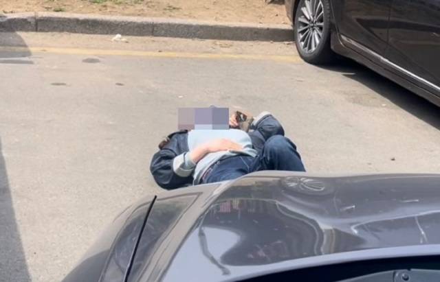 지난 1일 부산 해운대구 반여농산물도매시장 야외 주차장에서 주차 자리를 맡기 위해 바닥에 드러누운 여성. 온라인 커뮤니티 캡처