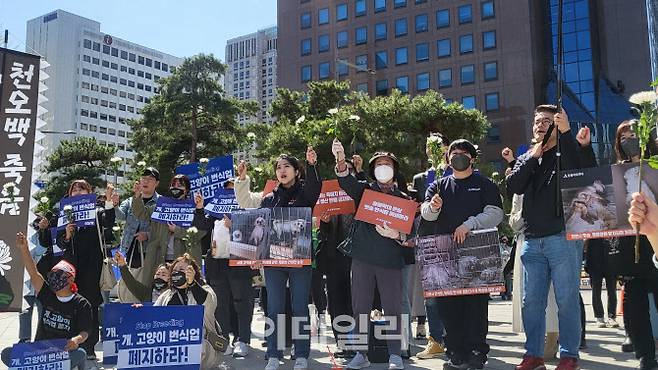 4월 8일 서울 종로구 보신각 앞에서 열린 위령제에서 번식장·펫샵 폐지를 촉구하는 시민들이 추모 차원에서 국화꽃을 들고 동물생산업 폐지 구호를 외치는 모습(사진=이데일리 김화빈 기자)