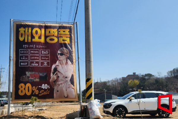 8일 오후 경기 김포시 월곶면의 한 의류 판매 매장 입구에 명품 브랜드 제품을 판매한다는 홍보물이 세워져있다.[사진=송승윤 기자]