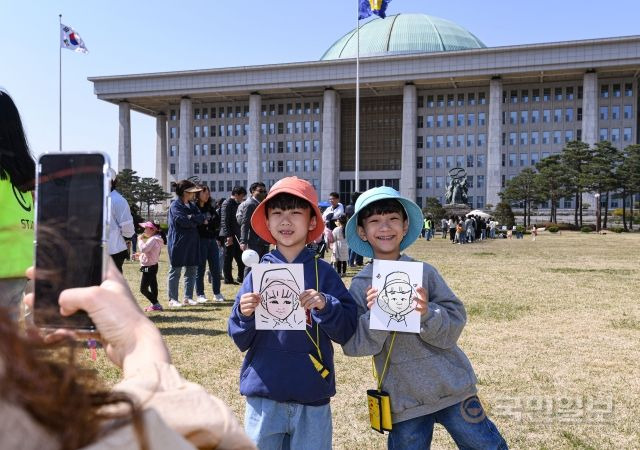 9일 서울 여의도 국회에서 열린 국회 개방행사 '국회의 봄, 희망을 피우다'를 찾은 어린이들이 자신의 캐리커처를 든 채 기념촬영을 하고 있다.