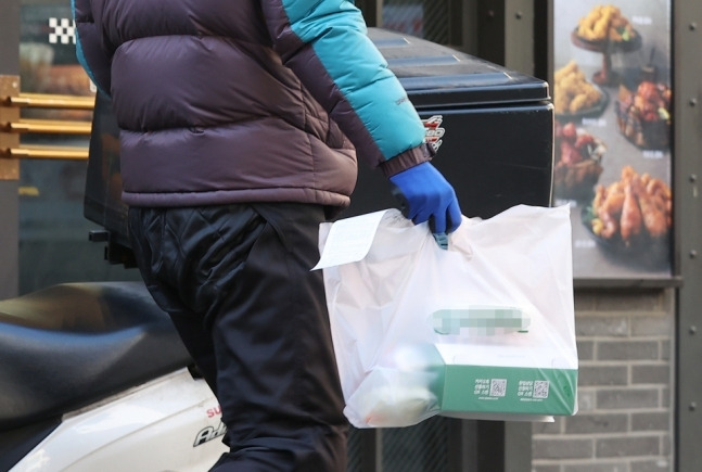 서울 시내 한 음식점 거리에서 배달 라이더가 음식을 오토바이에 싣고 있다. 사진|연합뉴스