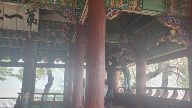 11일 강릉 산불이 확산하면서 국가지정문화재 보물로 지정된 강릉 ‘경포대’를 위협하자 문화재청 관계자가 자욱한 연기 속에서 경포대의 현판을 떼내고 있다. 문화재청 제공