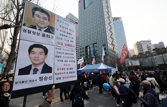 지난달 4일 오후 서울 중구 숭례문 앞 대로에서 촛불행동 주최로 열린 29차 촛불대행진에서 한 참가자가 아들의 학교폭력 전력이 드러나 경찰청 국가수사본부장에서 낙마한 정순신 변호사와 그를 추천한 윤희근 경찰청장을 규탄하는 손팻말을 들고 있다. 2023.3.4. 연합뉴스