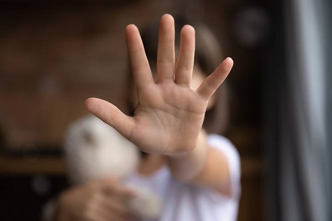 This photo shows a concept of a child showing a stop sign. (123rf)