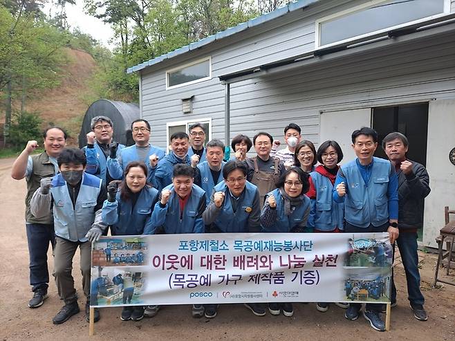 포항시 북구 기계면 소재 한 공방에서 목공예봉사단이 재능나눔을 실천한 가운데 포스코 포항제철소 봉사단이 기념 촬영을 하고 있다.