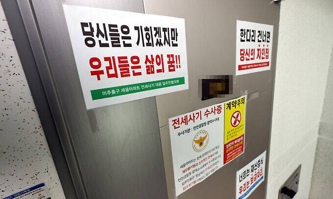 17일 전세사기 피해로 숨을 거둔 30대가 거주한 인천 미추홀구 아파트 현관문에 전세사기 피해 수사 대상 주택을 알리는 안내문이 부착돼 있다. 피해자가 세상을 등진 사이 ‘당신들은 기회겠지만 우리들은 삶의 꿈’ ‘한 다리 건너면 당신의 지인 집’ 등의 내용을 담은 안내문만 덩그렇게 현관문을 지키고 있다. 연합뉴스