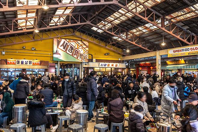 예산시장 장옥 마당. 시장 내 가게에서 사온 음식을 둥그런 스테인리스 테이블에 펼쳐 놓고 먹는 사람들과 자리 나기를 기다리는 사람들도 북적이고 있다. /조선DB