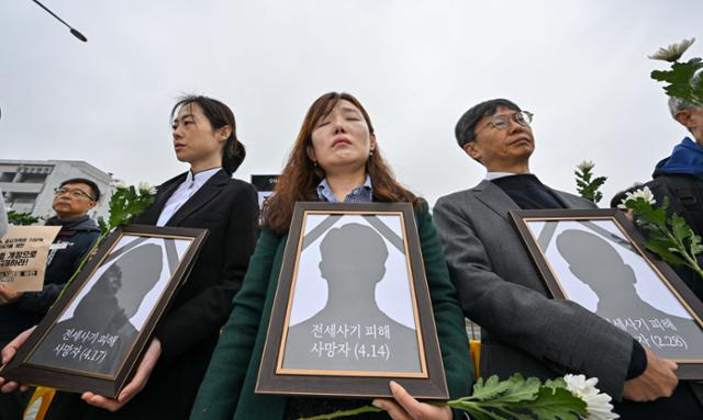 18일 서울 용산구 대통령실 앞에서 열린 전세사기·깡통전세 문제 해결을 위한 시민사회대책위원회 출범 기자회견에서 안상미(가운데) 인천 미추홀구 전세사기 피해 대책위원장 등 참가자들이 전세사기 피해자들 영정을 들고 있다. 최주연 기자