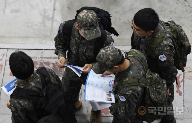 18일 경기도 고양시 킨텍스에서 열린 '2023 전반기 국군장병 취업박람회'에서 국군장병들이 안내 책자를 살펴보고 있다.