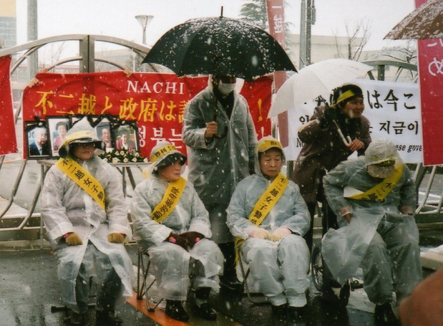 ▲ 일본 전범기업 후지코시 정문에서 눈을 맞아가며 항의 시위 중인 강제동원 피해자들(2010년 3월9일). 이들은 '근로정신대'란 이름으로 끌려가 노예노동을 강요당했다. Ⓒ민족문제연구소