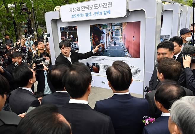 한국보도사진상 대상 수상자인 박동욱 디지털타임스 기자가 20일 서울 광화문광장에서 열린 제59회 한국보도사진전 개막식에서 김진표 국회의장을 비롯한 내빈들에게 대상 수상작에 대해 설명을 하고 있다. 사진공동취재단