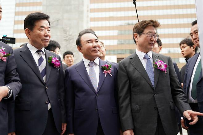 김진표(왼쪽) 국회의장, 윤홍근 한국사진기자협회 자문위원장·제너시스 BBQ그룹 회장, 박보균 문화체육관광부 장관이 20일 서울 종로구 광화문 광장에서 열린 제59회 한국보도사진전 개막식에 참석해 전시된 사진을 보고 있다.