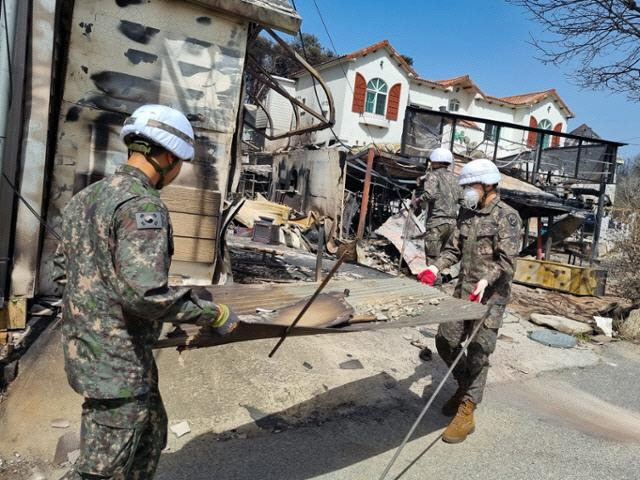 ▲ 육군 8군단 예하 102기갑여단 장병들이 강릉산불 피해 현장에서 12일 잔해물을 정리하는 대민지원 활동을 하고 있다. [육군 8군단 제공]