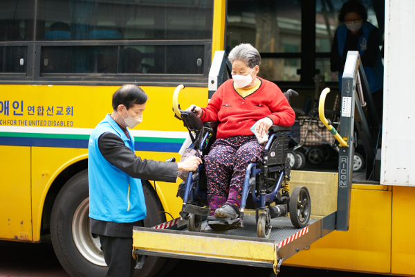 순복음노원교회 장애인선교회 봉사자가 휠체어를 탄 한 성도의 버스 하차를 돕고 있다. 사회복지법인 성민 제공