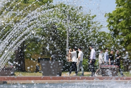 서울 낮 최고 기온이 27도로 예보된 19일 오후 서울 여의도 물빛광장에서 시민들이 분수 옆을 지나고 있다. 연합뉴스