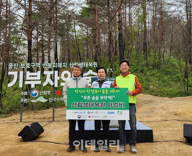 지난 21일 경북 울진군 산불피해지‘기부자의 숲’에서 산림생태복원 행사에서 (오른쪽부터)금동명 NH농협은행 부행장, 김재왕 대한적십자사 경북지사 회장, 류광수 한국수목원정원관리원 이사장이 기념촬영을 하고 있다. (사진=농협은행)