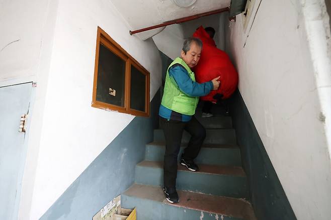 자활사업 참여자가 세탁물이 가득 든 자루를 나르고 있다.