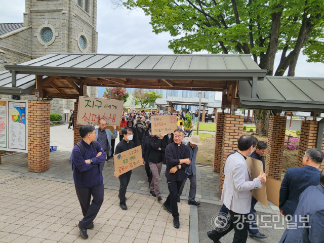 ▲ 천주교 춘천교구 소속 사제들과 신자들이 지난 22일 춘천 죽림동 성당에서 지구의 날 미사를 마치고 거리 행진을 하는 모습.