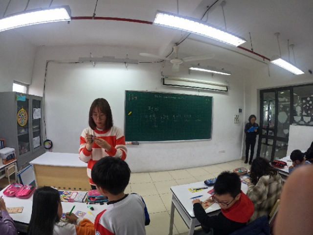 A Korean language teacher and her fifth-grade students make "paengi," Korean spinning tops, during a class on Feb. 8, 2023. (Choi Jae-hee / The Korea Herald)