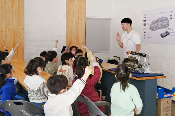 LG마그나 직원이 LG마그나가 생산한 부품을 교구로 활용해 학생들에게 전기차에 대해 설명하고 있다. [사진제공=LG마그나]