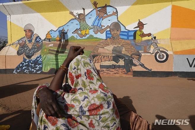 [와가두구(부르키나파소)=AP/뉴시스]지난 3월1일 부르키나파소 와가두구에서 한 여성이 벽화를 바라보고 있다. 부르키나파소 정부가 최근 북부에서 어린이 7명을 불법적으로 살해하는 동영상이 공개된 후 보안군에 의한 인권 유린 혐의에 대한 조사를 시작한 가운데 23일(현지시간) 부르키나파소 북부에서 군복을 입은 남성들에 의해 최소 60명의 민간인이 사망했다. 2023.04.24.