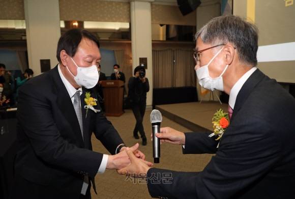 2021년 11월 서울 중구 한국프레스센터에서 열린 신평 변호사 출판기념회에 참석한 당시 윤석열 국민의힘 대선후보가 신 변호사와 인사를 나누고 있다. 서울신문 DB