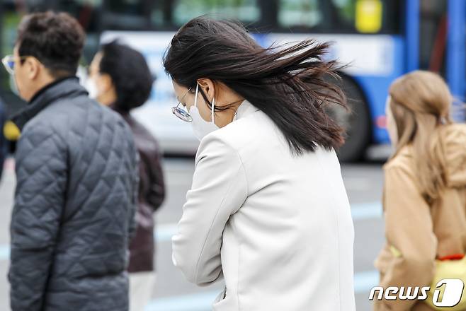 비가 그치고 쌀쌀한 날씨를 보인 26일 서울 시내 한 거리에서 시민의 머리카락이 바람에 날리고 있다. 2023.4.26/뉴스1 ⓒ News1 김도우 기자