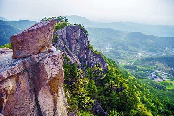 아찔한 득도바위 끝에 걸터앉아 있는 등산객.