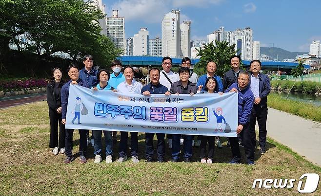 부산시선관위 직원들과 각 정당 관계자들이 함께 온천천에서 줍킹 행사 후 기념사진을 찍고 있다(부산시선관위 제공)