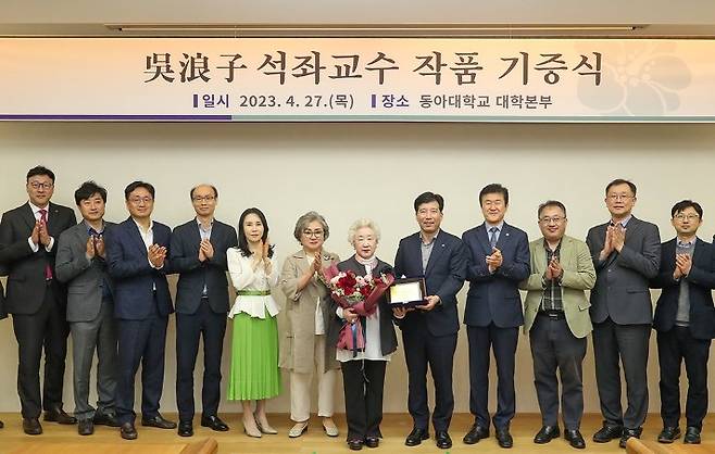 오낭자 석좌교수와 이해우 동아대 총장(왼쪽 일곱번째부터), 동아대 본부위원들이 27일 동아대 승학캠퍼스에서 작품 기증 기념촬영을 하고 있다. 동아대 제공