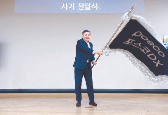 지난 달 30일 경기 성남시 포스코DX 판교사옥에서 열린 비전 선포식에서 정덕균 포스코DX 대표이사 사장이 직원대표들로부터 사기를 전달 받아 흔들고 있다. 사진 포스코DX=연합뉴스