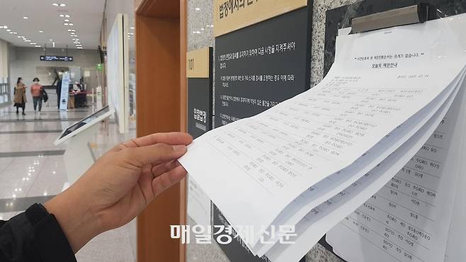 한 시민이 서울동부지방법원 입찰법정에 안내된 입찰물 정보를 살펴보고 있다. [이승환 기자]